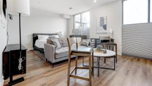 ein Wohnzimmer mit einem Sofa und einem Tisch in der Unterkunft Landing - Modern Apartment with Amazing Amenities (ID7010) in Bala-Cynwyd