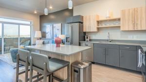 a kitchen with a counter and a table and chairs at Landing - Modern Apartment with Amazing Amenities (ID2399X88) in Salt Lake City