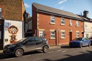 dois carros estacionados ao lado de uma rua em Watford Central Serviced Apartments em Watford