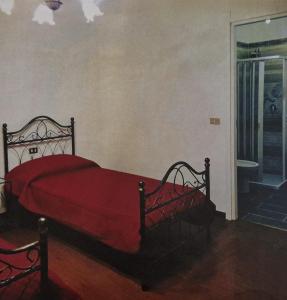 1 dormitorio con 1 cama con colcha roja en Hotel Mondial 2, en Villasor