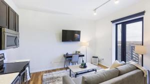 een woonkamer met een bank en een tafel bij Landing - Modern Apartment with Amazing Amenities (ID8398X30) in Omaha