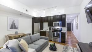 a living room with a couch and a kitchen at Landing - Modern Apartment with Amazing Amenities (ID8398X30) in Omaha