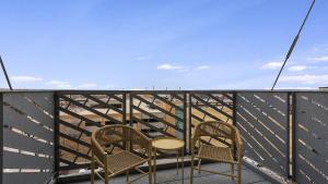 2 sillas y una mesa en el balcón en Landing - Modern Apartment with Amazing Amenities (ID8398X30) en Omaha