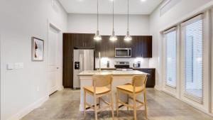 a kitchen with a island with two chairs and a counter at Landing - Modern Apartment with Amazing Amenities (ID6650X47) in Fort Worth