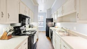 een keuken met witte kasten en een zwarte kachel bij Landing - Modern Apartment with Amazing Amenities (ID7786X36) in Nashville