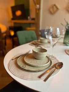 una mesa con platos y cucharas sobre una mesa blanca en De Koer Kanne, en Kanne
