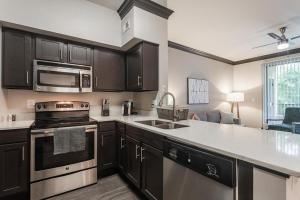 cocina con fregadero y fogones horno superior en Landing - Modern Apartment with Amazing Amenities (ID4583X64) en Houston