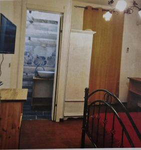 Habitación con una puerta que conduce a una cocina con fregadero. en Hotel Mondial 2, en Villasor
