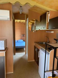 a room with a kitchen and a bedroom with a bed at Camping Les Amandiers in Castelnau-de-Guers +9 photos