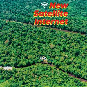 an aerial view of a forest with a new satellite internet sign at Jacamar Lodge Expeditions in Iquitos