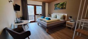 a bedroom with a bed and a table and a chair at Brauhaus am See in Oberthulba