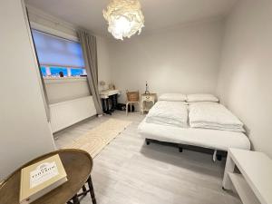 Schlafzimmer mit einem Bett, einem Tisch und einem Fenster in der Unterkunft Apartment in Reykjavikurvegur - Birta Rentals in Hafnarfjördur