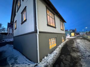 ein Haus mit Schnee an der Seite in der Unterkunft Apartment in Reykjavikurvegur - Birta Rentals in Hafnarfjördur