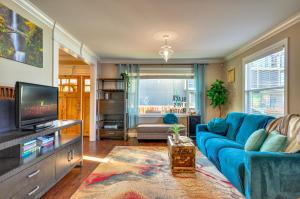 a living room with a blue couch and a tv at Alberta Arts District Home with Private Hot Tub! in Portland
