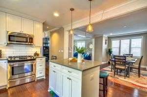 a kitchen with white cabinets and a dining room at Alberta Arts District Home with Private Hot Tub! in Portland