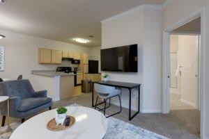 een woonkamer met een tafel en een keuken bij Landing - Modern Apartment with Amazing Amenities (ID3381X66) in Mount Juliet