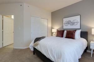 een slaapkamer met een groot wit bed met kussens bij Landing - Modern Apartment with Amazing Amenities (ID3381X66) in Mount Juliet