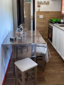 uma cozinha com uma mesa e cadeiras numa cozinha em Casa muy iluminada con estacionamiento propio. em Piriápolis