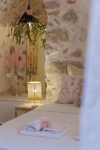 - une chambre avec un lit, 2 serviettes et des bougies dans l'établissement Iliana's house - spacious cave house in the center of Areopolis, à Areópoli