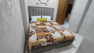 - un lit avec une couverture et un oreiller jaune dans l'établissement Ibraimo, à Fès