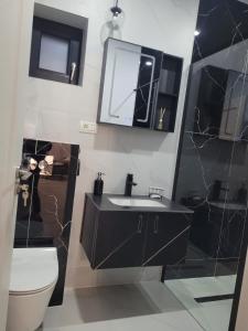 y baño con lavabo, aseo y espejo. en TAG Apartament en Timisoara