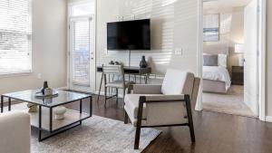 uma sala de estar com um quarto com uma cama e uma mesa em Landing - Modern Apartment with Amazing Amenities (ID1196X495) em Fishers