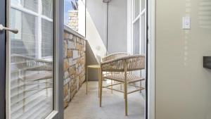uma cadeira sentada numa varanda ao lado de uma janela em Landing - Modern Apartment with Amazing Amenities (ID1196X495) em Fishers