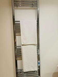 a towel rack with white towels in a bathroom at Play Away Lodge in Basildon