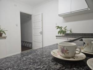 a kitchen with two cups on a counter at Espaço Semente Poa Lírio in Porto Alegre