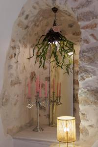 un lampadario a braccio con candele rosa su un tavolo di Iliana's house - spacious cave house in the center of Areopolis ad Areópolis