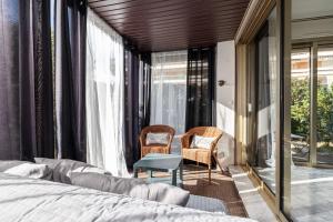 sypialnia z łóżkiem i 2 krzesłami w obiekcie LE GLOBE TROTTEUR w mieście Saint-Laurent-du-Var