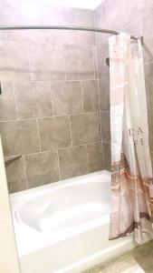 uma banheira com uma cortina de chuveiro na casa de banho em Downtown Houston Cozy Queen Suite em Houston
