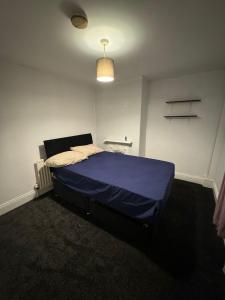 um quarto com uma cama azul num quarto em Huddersfield house em Huddersfield