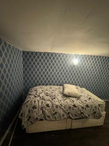uma pequena cama num quarto com uma parede azul em Huddersfield house em Huddersfield