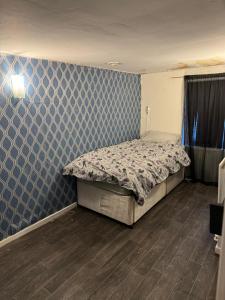 1 dormitorio con cama y pared azul en Huddersfield house en Huddersfield