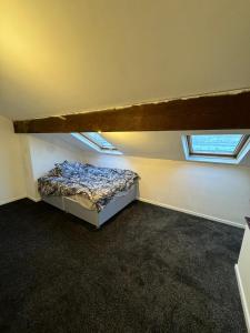 um quarto com uma cama num quarto com janelas em Huddersfield house em Huddersfield