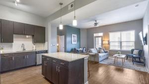 uma cozinha e sala de estar com um sofá e uma mesa em Landing - Modern Apartment with Amazing Amenities (ID5045X9) em San Antonio