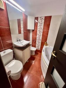 ein Badezimmer mit einem WC, einem Waschbecken und einer Badewanne in der Unterkunft Amy's Bright Apartment in Constanţa