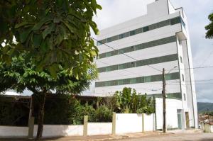 um edifício branco com uma árvore em frente em BellaVista Hotel em Bonito