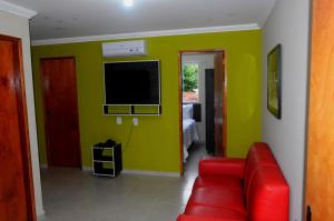 a living room with a red couch and a green wall at BellaVista Hotel in Bonito