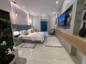 een slaapkamer met een bed en een flatscreen-tv bij ‏Riyadh Almajidiya Studio in Riyad