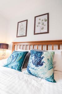 a bedroom with a bed with blue and white pillows at Luxurious 5 Bed Property! in Woodley