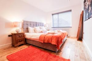 a bedroom with a large bed and a red rug at Luxurious 5 Bed Property! in Woodley
