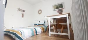 ein kleines Schlafzimmer mit einem Bett und einem Tisch in der Unterkunft Appartement T2 au 1er étage in Margny-lès-Compiègne