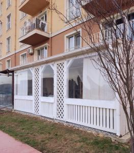 a white building with windows and a balcony at Antonia's Cozy Studio in Ştefăneştii de Jos