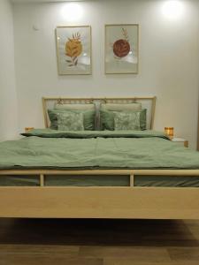 a bed in a bedroom with three pictures on the wall at Antonia's Cozy Studio in Ştefăneştii de Jos