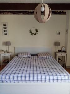 1 dormitorio con 1 cama con manta de cuadros azul en Kerfly, en Plouër-sur-Rance