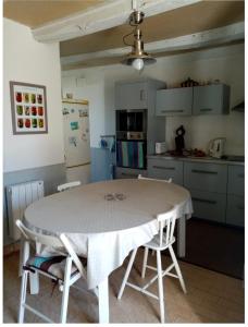 a kitchen with a table and chairs in a kitchen at Kerfly in Plouër-sur-Rance +15 photos
