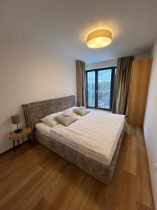 a bedroom with a large bed and a window at BlackDEER Apartment Liptov in Liptovský Mikuláš