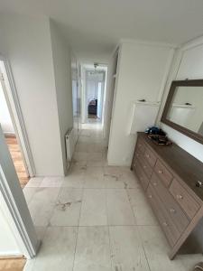 an empty hallway with a dresser and a mirror at 2 Bedrooms. London Skyline view 3 beds and balcony in London